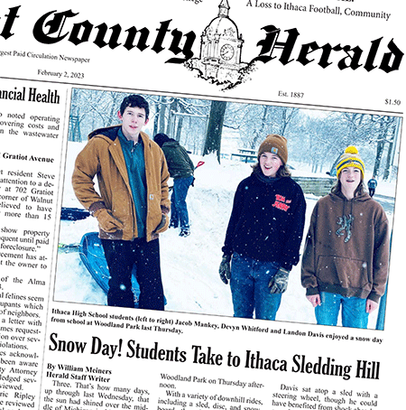 Picture of Newspaper article about sledding on a snow day showing teenage boys outside in winter gear.