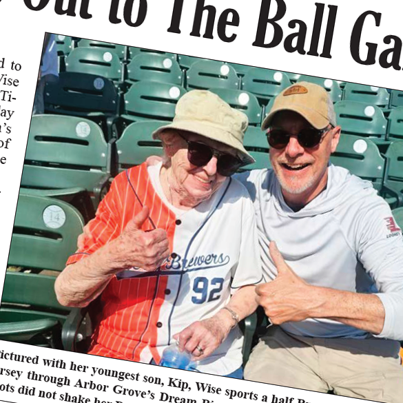 Elderly woman in a hat and sunglasses with her adult son at a ballgame